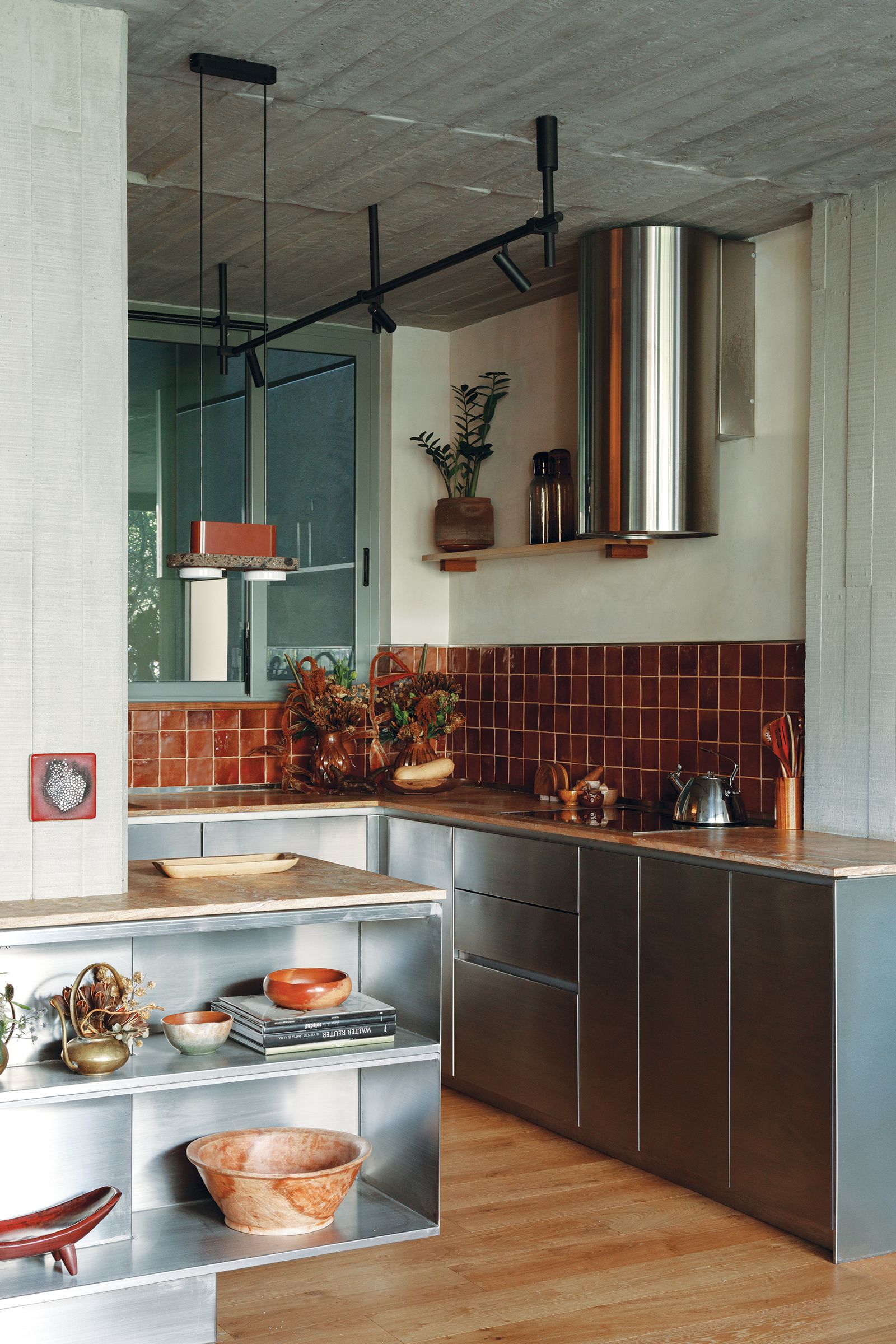 Cocina que combina madera concreto y metal.