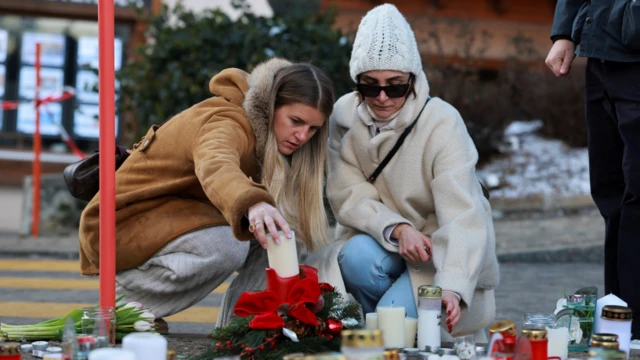 Mujeres colocan velas por las víctimas del bar Le Constellation, luego de un incendio durante una fiesta de Nochevieja 