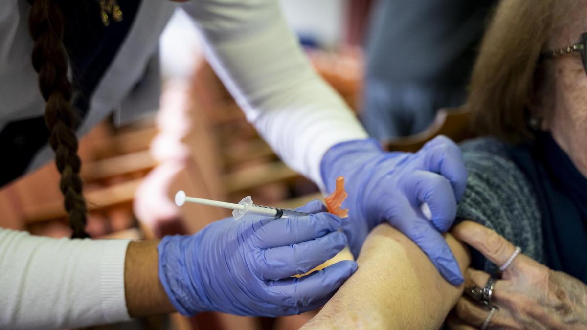 Una enfermera vacuna a una mujer en una residencia de mayores de Cáceres.