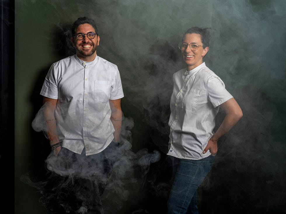 two individuals standing in a smoky environment