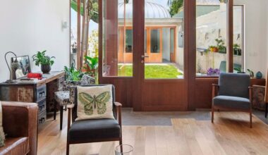 Unos arquitectos convierten un solar estrecho y alargado en una casa preciosa con un patio ajardinado interior y una oficina con cúpula