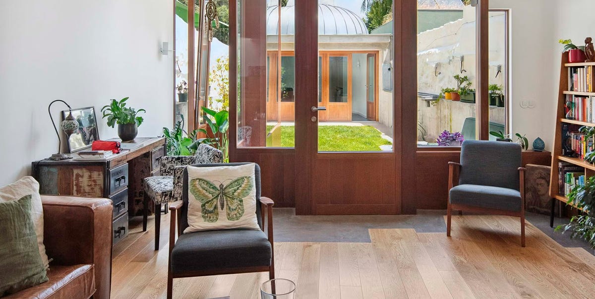 Unos arquitectos convierten un solar estrecho y alargado en una casa preciosa con un patio ajardinado interior y una oficina con cúpula