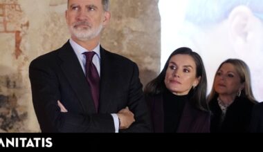 la Reina, con traje color vino y pendientes con mensaje