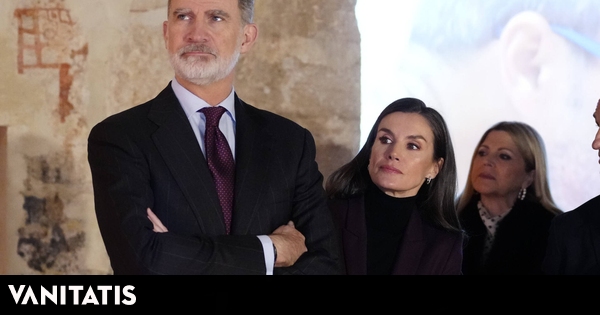 la Reina, con traje color vino y pendientes con mensaje