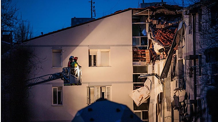 Los bomberos acceden con la escala a la zona explotada en la cuarta planta