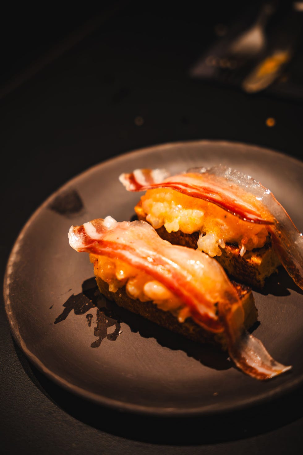 two pieces of sushi on a black plate