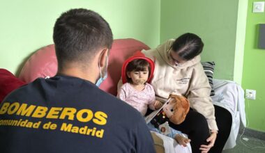 Bombero entregando regalo a niña ingresada