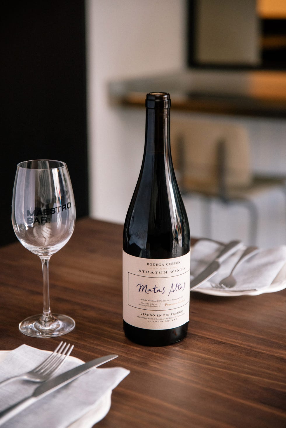 wine bottle and glass set at a dining table