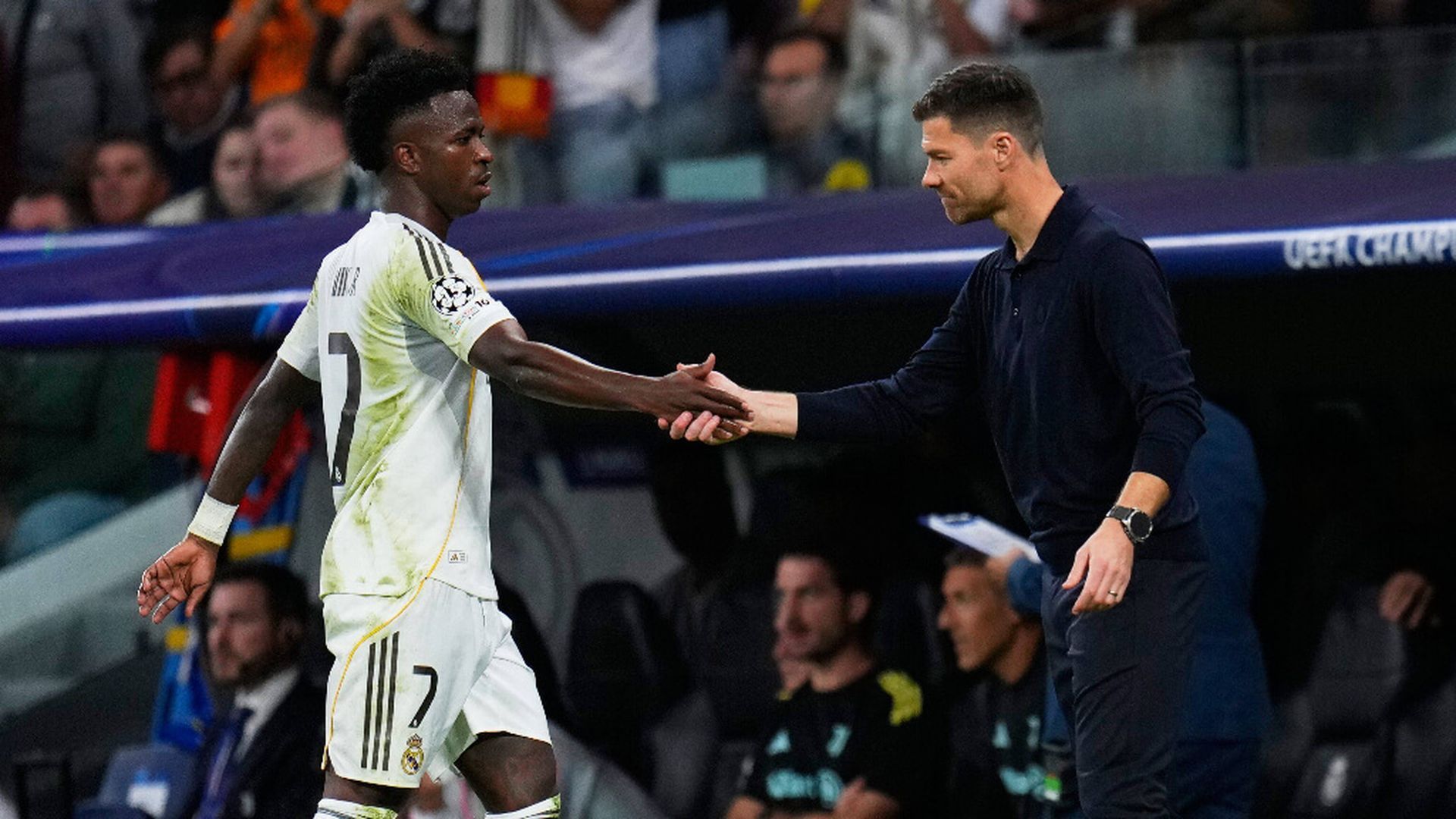 Vinicius y Xabi Alonso se saludan en el banquillo.