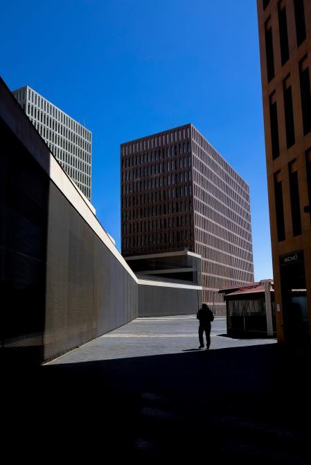 Figura entre edificios y sombras.