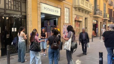 Unos fans de Twice intercambian cromos delante de la galería el lunes 