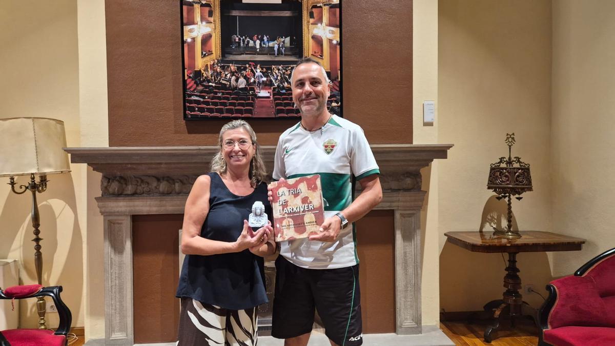 Carlos San José entrega una réplica de la Dama de Elche a la teniente de alcalde de Girona, Silvia Aliu, durante la recepción institucional celebrada en el Ajuntament tras completar su recorrido en bicicleta