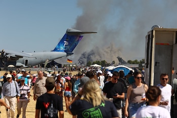 La gente observa cómo se eleva humo tras el accidente de un avión de combate griego F-4 Phantom durante el espectáculo aéreo Athens Flying Week en Tanagra, Grecia (Nikos Mitrousias/Intime via REUTERS)