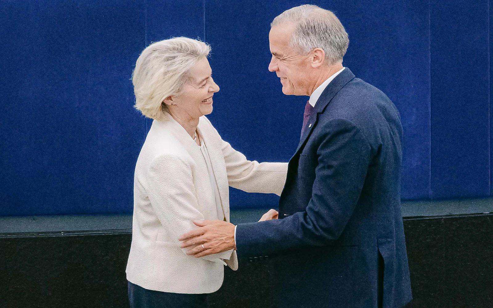 This handout photograph taken and released by the European Union on September 16, 2026 shows European Commission President Ursula von der Leyen (L) shaking hands with Canada's Prime Minister Mark Carney during her annual keynote address to the European Parliament in Strasbourg, eastern France.