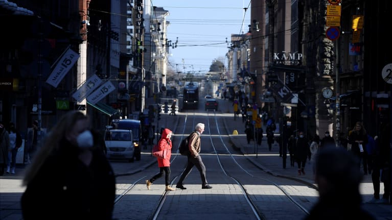 Jalankulkijoita ylittämässä Aleksanterinkatua Helsingissä 3. maaliskuuta 2021.