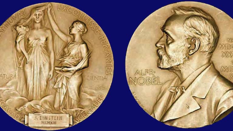 Albert Einsteinin saama Nobel-mitali kummaltakin puolelta. Toisella on kaksi roomalaiista naishahmoa ja motto, toisella Alfred Nobelin profiilikuva. 