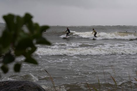 Surffaajat nauttivat myrskyn nostattamista aalloista Uniluodossa.
