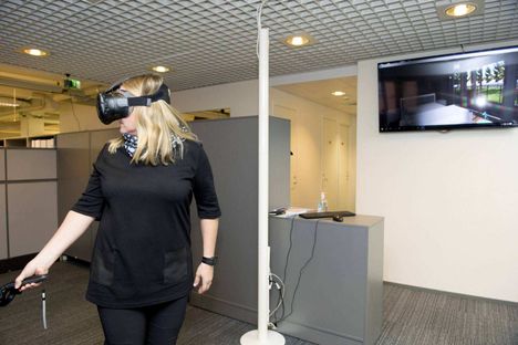 Rejlersin suunnittelupäällikkö Tytti Kaitala kokeilee virtuaalilaseja. Se, mitä hän näkee, ilmestyy myös viereiselle näytölle.