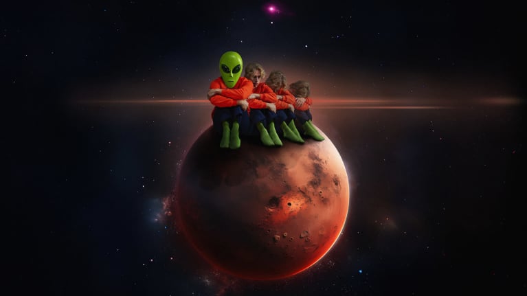 Piirros, jossa on planeetta avaaruudessa, planeetan päällä istuu ufohahmo ja kolme ihmistä.