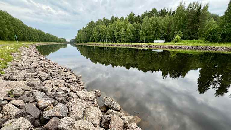 Saimaan kanavan reunakivikkoa ja kanava tekee kaarteen.