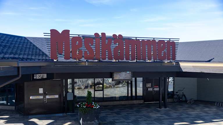 Hotelli Mesikämmenen etupihaa. Iso Mesikämmen kyltti katolla.