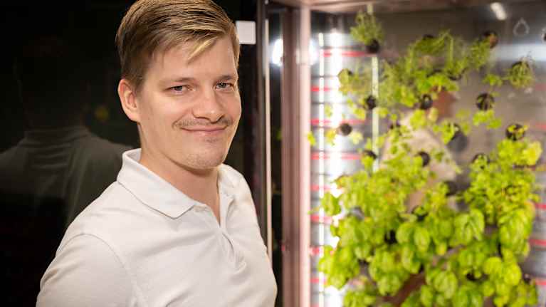 Oliver Rotko seisoo kasvatuskaapin edustalla.