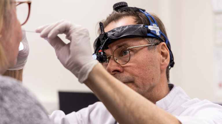 Heikki Löppönen, professori, erikoislääkäri tutkii koronarokote-tutkimuksen osallistuvaa vapaaehtoista.