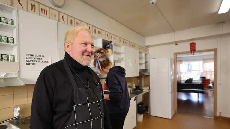Vapaaehtoistyöntekijä asunnottomien tekee makkarakastiketta asunnottomien keittiössä Turussa. 