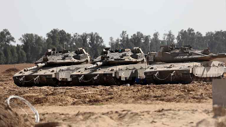 Israelin armeijan tankkeja hiekan keskellä rivissä. 