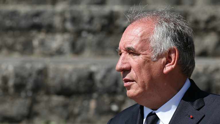 Francois Bayroun sivuprofiili. Taustalla on kiviseinä.