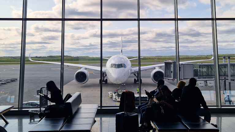 Finnairin Airbus A350-matkustajakone Helsinki-Vantaan lentoasemalla kuvattuna terminaalin ikkunan läpi. 
