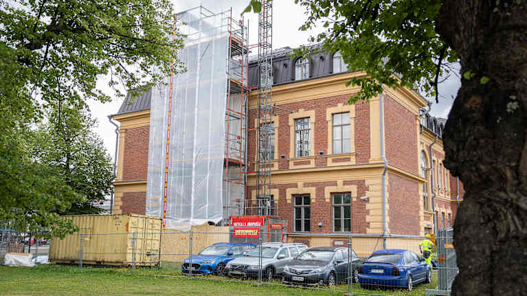 Aidatulla työmaa-alueella Joensuun taidemuseo, jonka julkisivusta osa on peitetty.