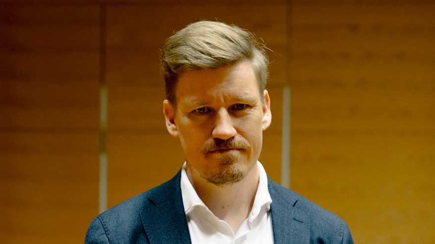 Henkilö seisoo oikeussalissa.