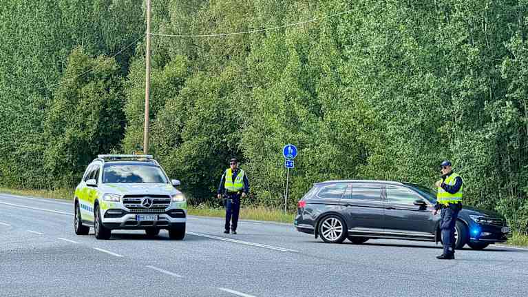 Poliisiautoja ja poliiseja autotiellä.