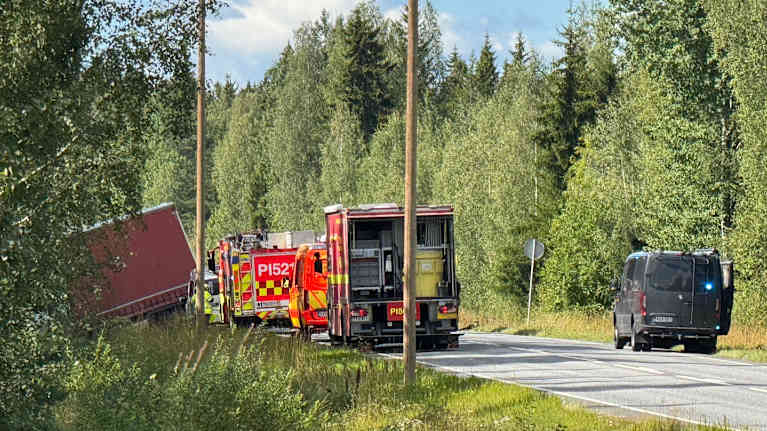 Pelastuslaitoksen ajoneuvoja tiellä ja kuorma-auto ojassa.