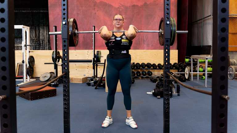 Kuulantyöntäjä Emilia Kangas tekee kyykkytreeniä painoilla punttisalilla.