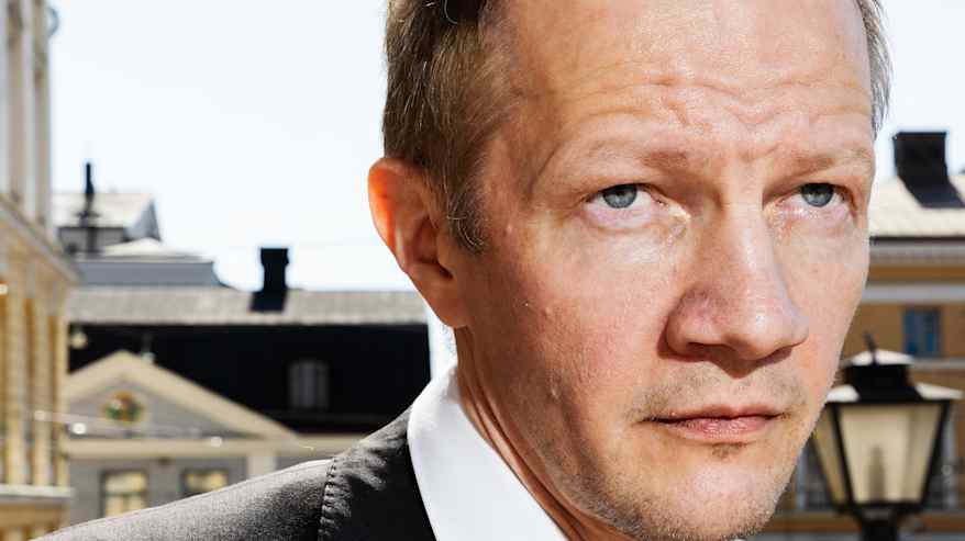 Matias Turkkila Senaatintorin liepeillä tummassa puvussa ja punaisessa kravatissaan.