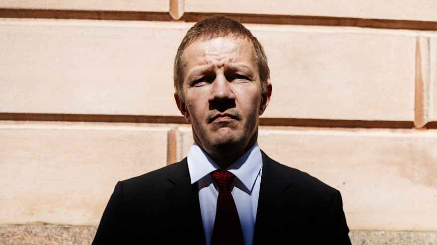 Matias Turkkila Senaatintorin liepeillä tummassa puvussa ja punaisessa kravatissaan.