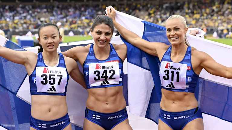 Saara Keskitalo, Nooralotta Neziri ja Lotta Harala poseeraavat Suomen lipun kanssa.