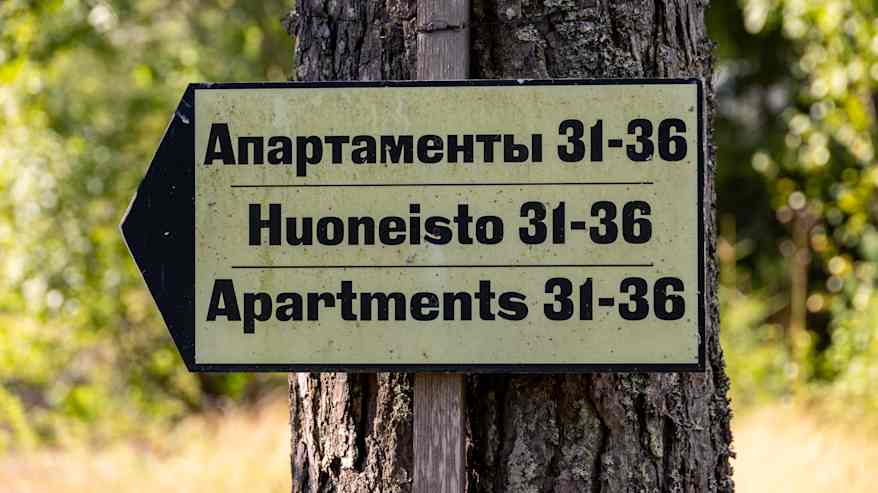 Suuntakyltti vanhan ja ränsistyneen leirikeskuksen alueella Suur-Miehikkälässä.