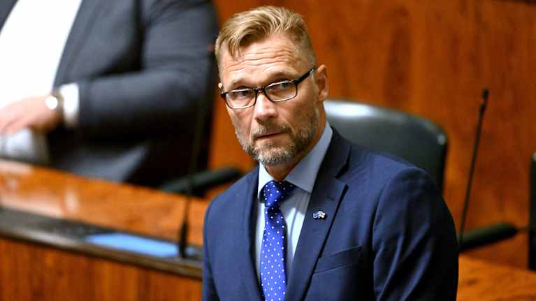 Kansanedustaja Tomi immonen eduskunnan istuntosalissa.