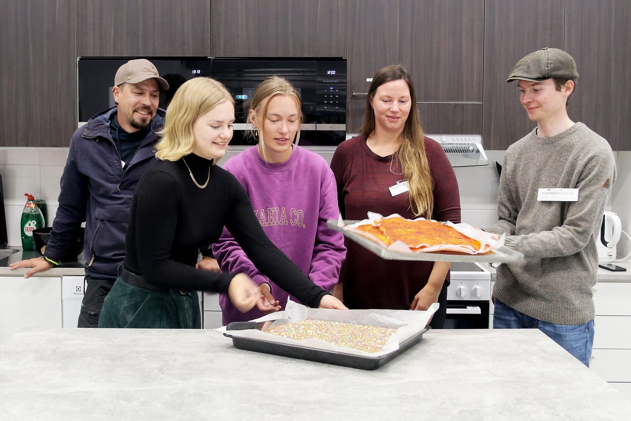 Tämän vuoden eräopasopiskelijat Laura Suomalainen (toinen vas.) ja Sofia Ahvenainen (kolmas vas.) valmistivat lumojen 30-vuotisjuhlaan mokkapaloja marttojen reseptillä. Opiskelutoverit Jaakko Haltia, Noora Nuotio ja Jooseppi Myllyneva seurasivat vieressä. Uusilla lumoilla oli kaksi viikkoa koulua takana. ”Ryhmähenki on hyvä. Meitä on tiivis, pieni porukka”, he kertoivat.