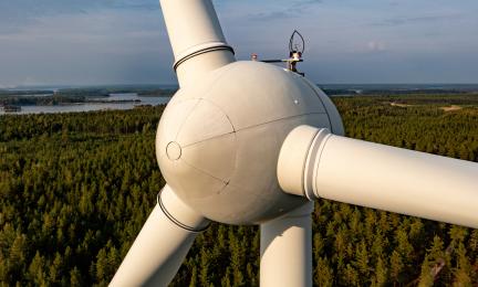 Lähikuva tuulimyllystä, jonka taustalla näkyy metsää.