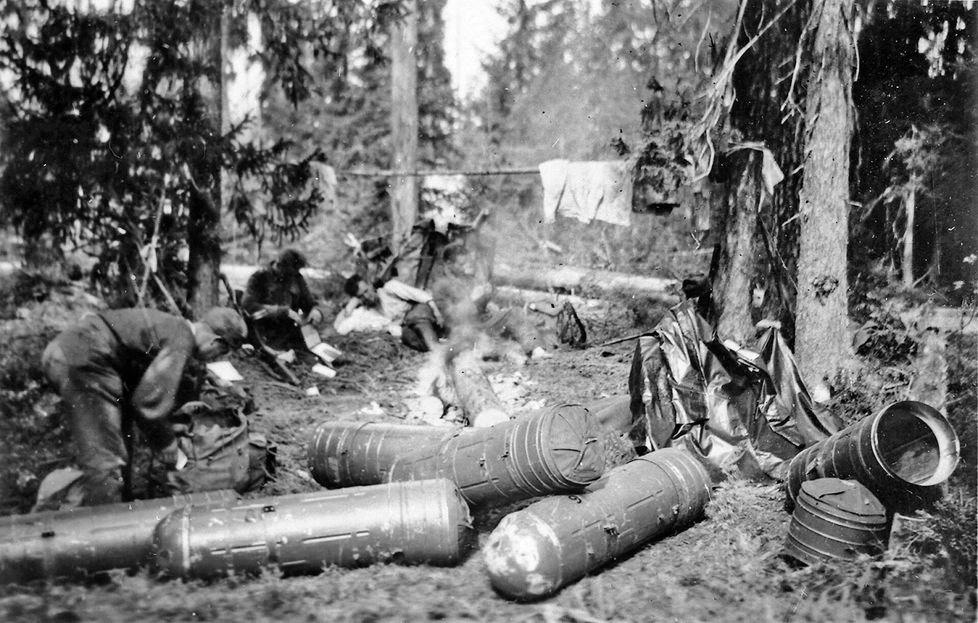 Suomalaisten kaukopartiomiesten leiri todennäköisesti Arkangelin suunnalla. Etualalla ”torpedoja”, joissa miehille pudotettiin ilmasta täydennystä.