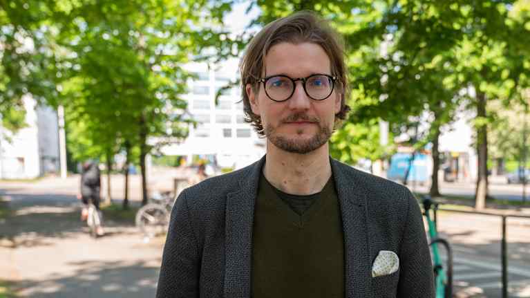 Rikosoikeuden apulaisprofessori Tatu Hyttinen Turun yliopistosta seisomassa kaupunkimaisemassa. 