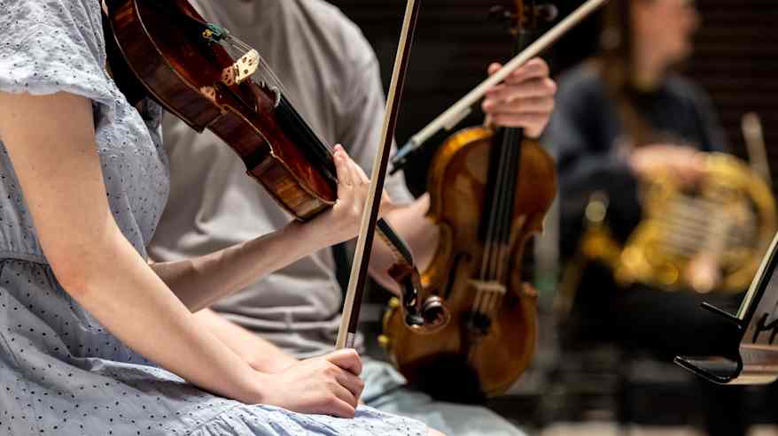 Orkesteri harjoittelee klassisen musiikin kappaletta.