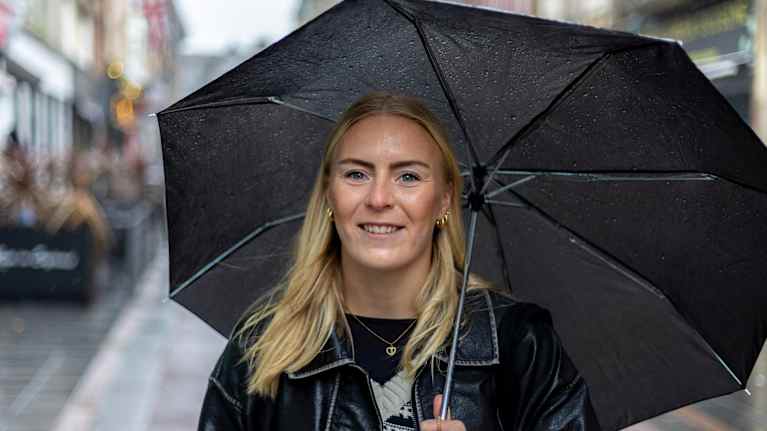 Jalkapalloilija Jutta Rantala poseeraa sateenvarjon kanssa Leicesterissä.