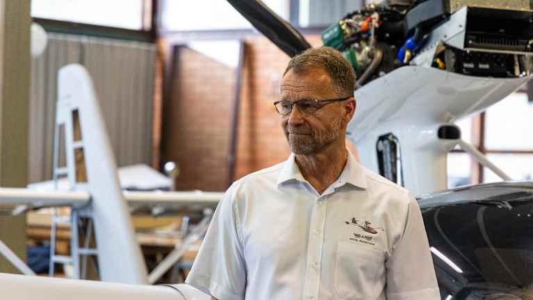 Atol Aviationin myyntijohtaja Anssi Rekula rakennettavan lentokoneen vieressä.