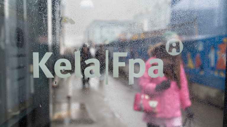 Kelan logo kuvattuna toimipisteen ovessa sen ollessa auki. 
