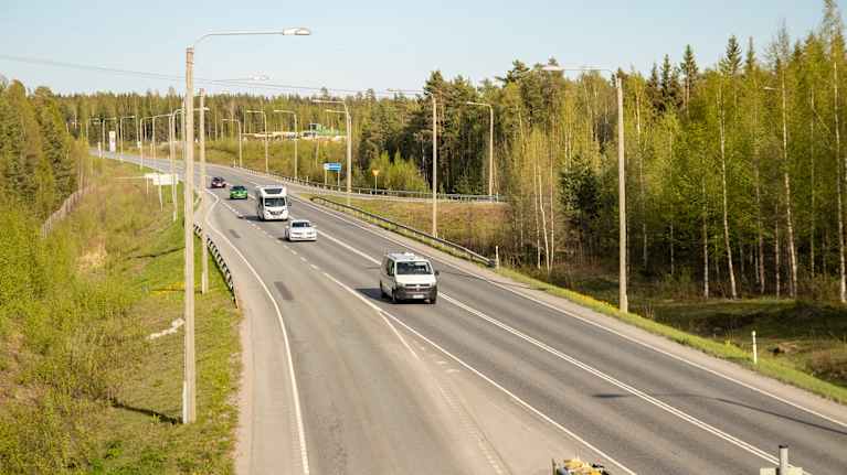 Auto ajamassa ysitiellä keväisessä auringonpaisteessa.